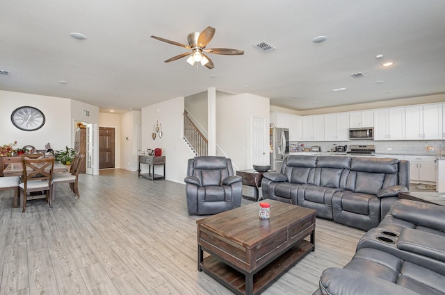 living room with ceiling fan and light hardwood / wood-style flooring