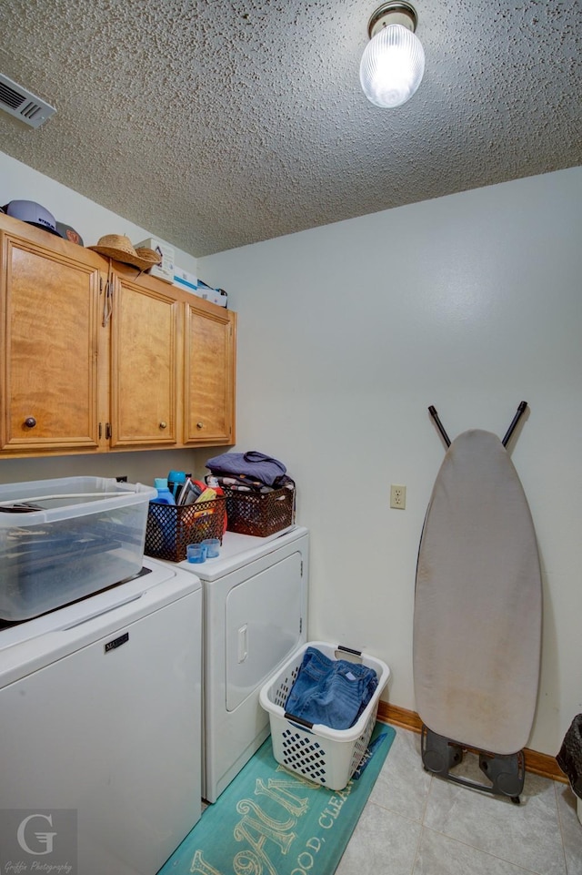 111 White Rd, Frierson, LA 71027 - laundry area featuring cabinets, washing machine and dryer, a textured ceiling, and light tile patterned floors