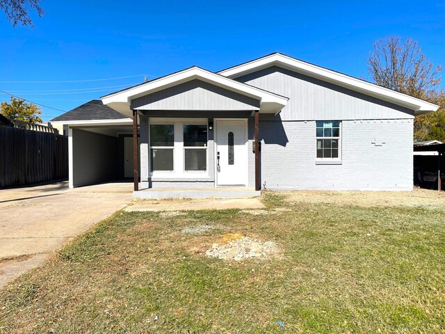 view of front of house with a front yard and a carport