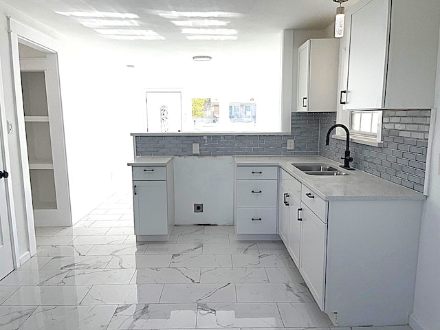 kitchen featuring sink, decorative backsplash, and white cabinets