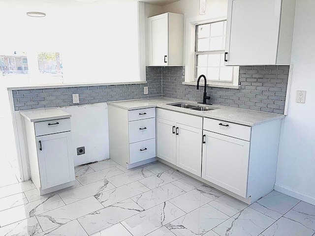 kitchen with sink, white cabinets, and decorative backsplash