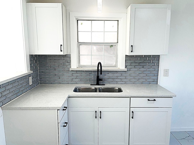 kitchen with white cabinetry, sink, a wealth of natural light, and backsplash