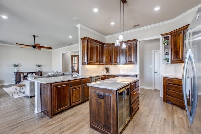 kitchen with pendant lighting, a kitchen island, light hardwood / wood-style floors, and sink