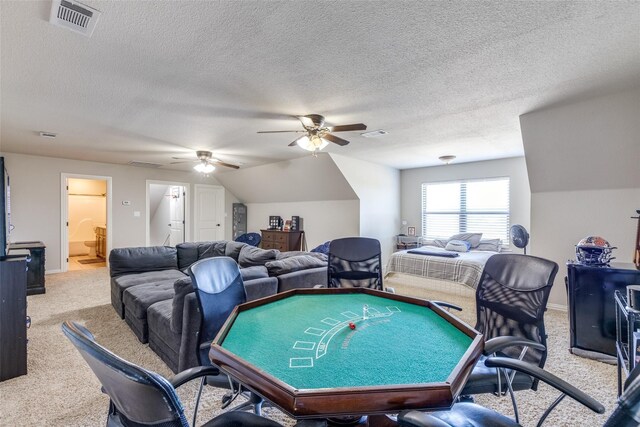 living room featuring a textured ceiling, ceiling fan, light colored carpet, and vaulted ceiling