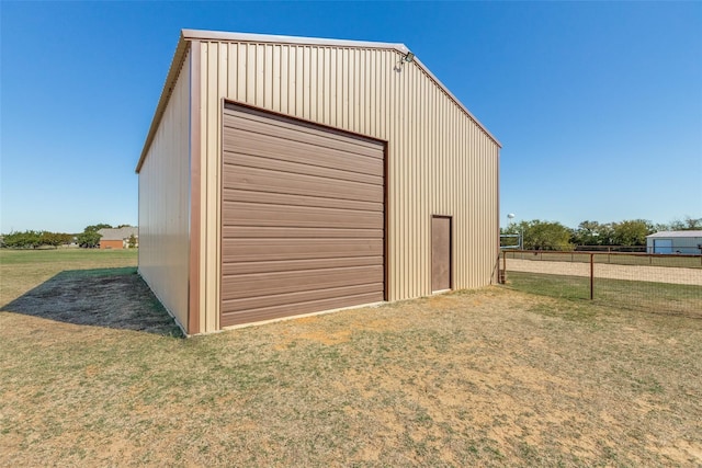 view of outdoor structure featuring a garage and a lawn