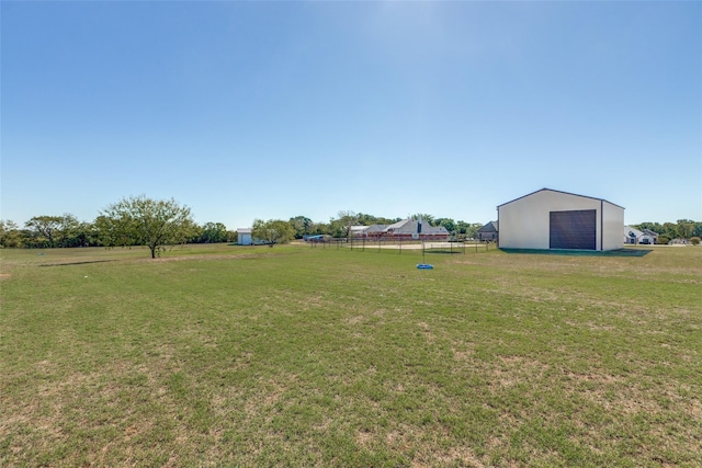 view of yard with a rural view and an outdoor structure