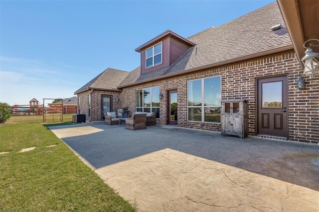 rear view of property with a lawn, a patio area, outdoor lounge area, and central air condition unit