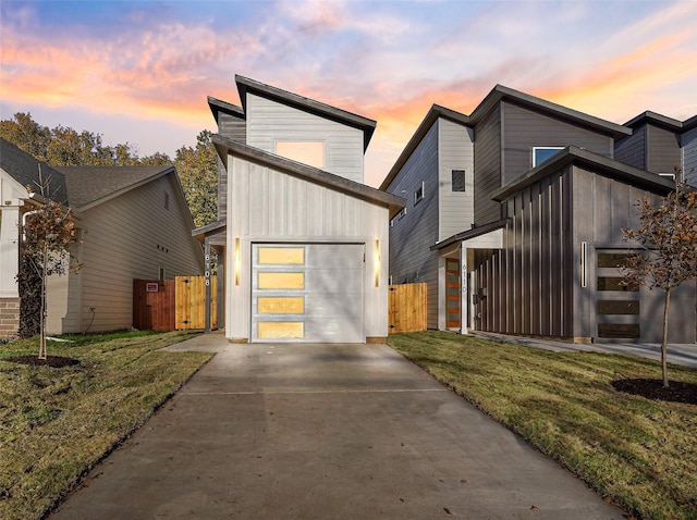 contemporary home featuring a garage and a lawn