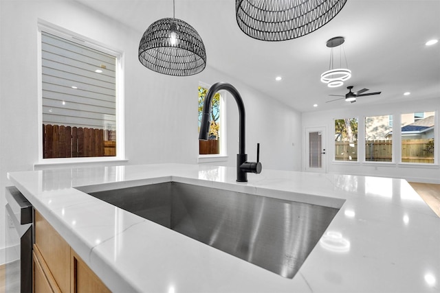 details featuring ceiling fan with notable chandelier, sink, light stone countertops, and hanging light fixtures