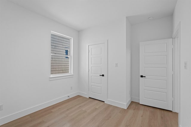 unfurnished bedroom with light wood-type flooring and a closet