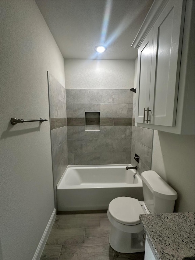 full bathroom with vanity, tiled shower / bath combo, and toilet