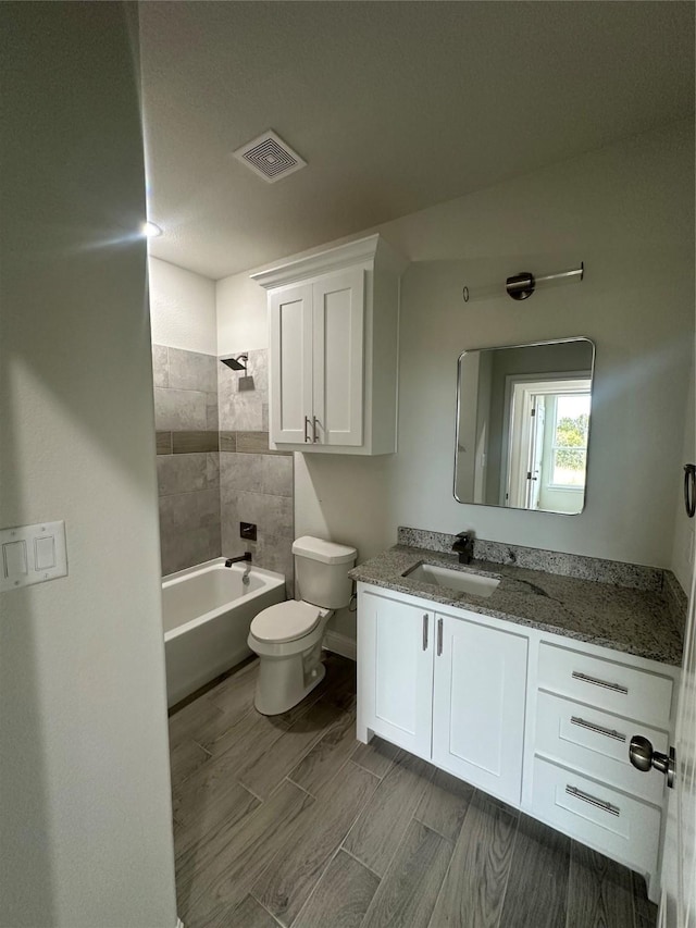 full bathroom featuring vanity, toilet, and tiled shower / bath