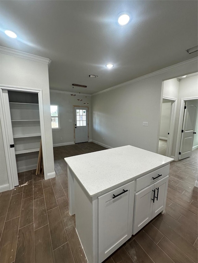 kitchen featuring a center island, white cabinets, and ornamental molding