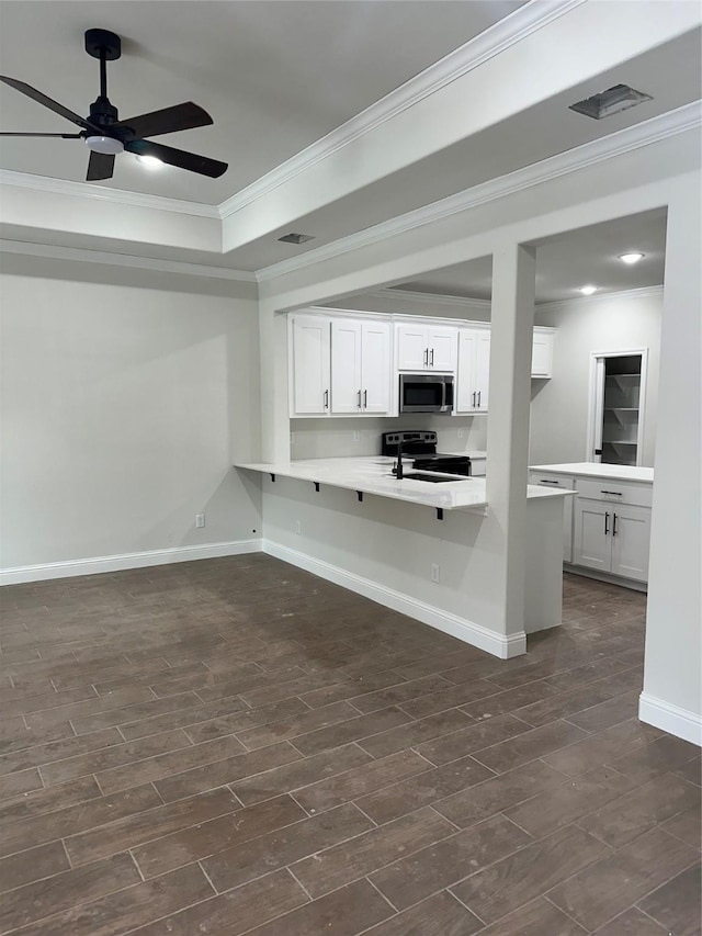 interior space featuring white cabinetry, sink, kitchen peninsula, crown molding, and a kitchen bar