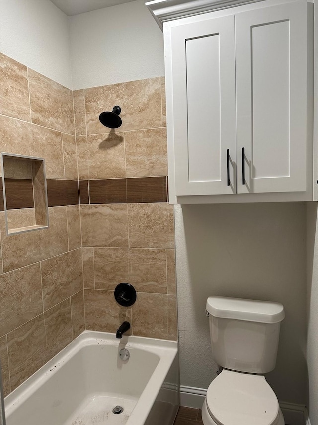 bathroom featuring toilet and tiled shower / bath