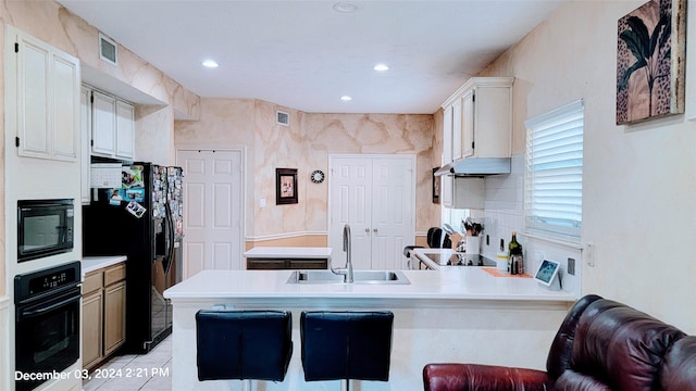 kitchen featuring kitchen peninsula, sink, white cabinets, and black appliances