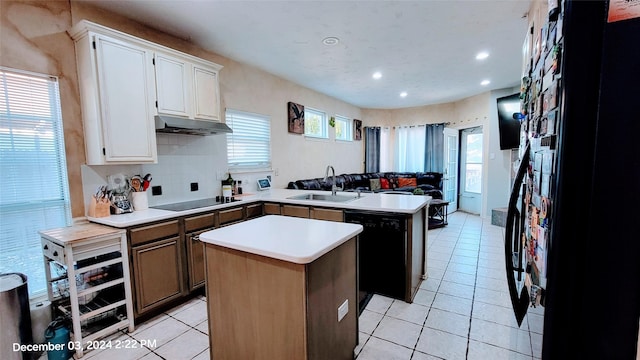 kitchen featuring light tile patterned flooring, sink, black appliances, a center island, and white cabinets