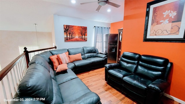 living room with hardwood / wood-style floors, vaulted ceiling, and ceiling fan