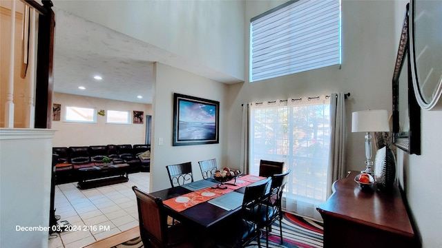 tiled dining space with a high ceiling