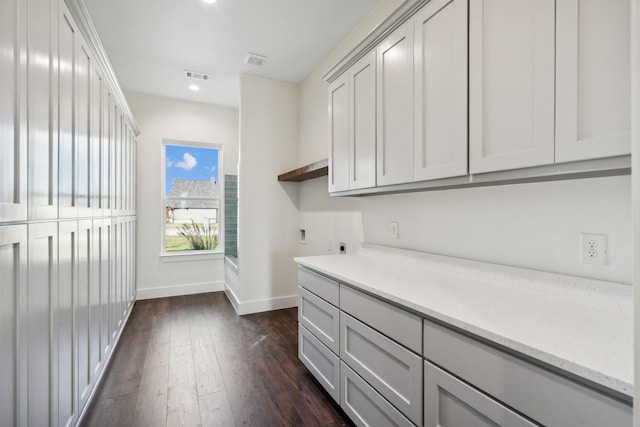 laundry area featuring hookup for an electric dryer, cabinets, and dark wood-type flooring