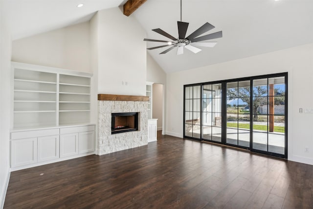 unfurnished living room featuring ceiling fan, dark wood-type flooring, high vaulted ceiling, beamed ceiling, and a fireplace