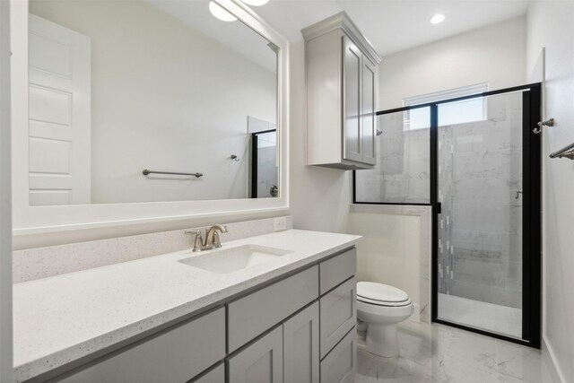 bathroom with vanity, toilet, and a shower with door