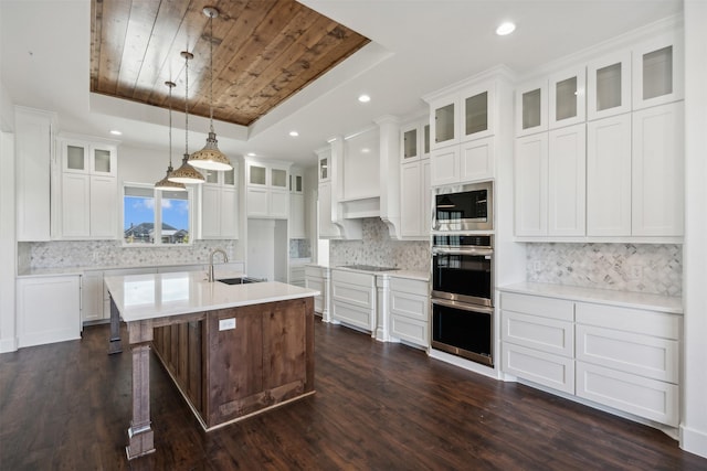 kitchen with sink, a raised ceiling, dark hardwood / wood-style floors, decorative light fixtures, and white cabinets