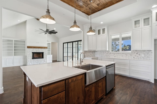 kitchen featuring dishwasher, an island with sink, vaulted ceiling, and sink