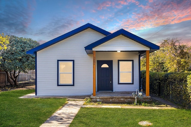 view of front of home featuring covered porch and a lawn