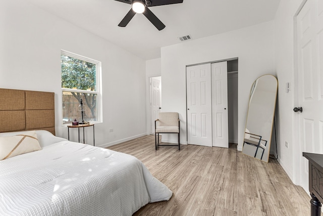 bedroom with a closet, light hardwood / wood-style floors, and ceiling fan