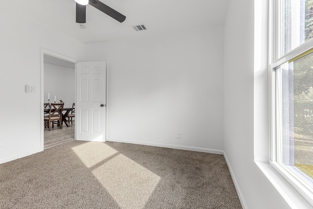 empty room with ceiling fan and carpet