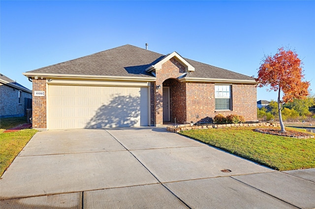 ranch-style house with a garage and a front lawn