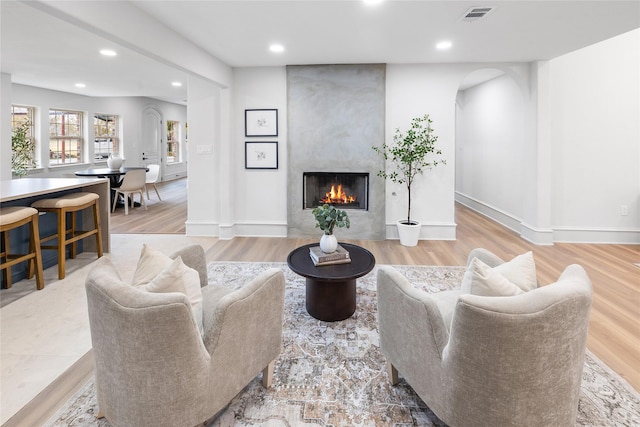 living room with light wood-type flooring and a fireplace