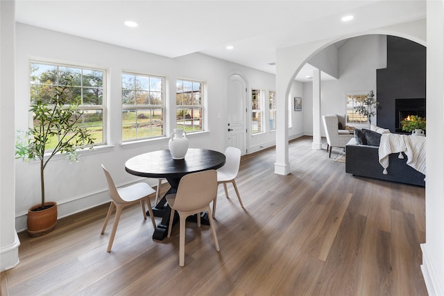 dining area with decorative columns and wood-type flooring