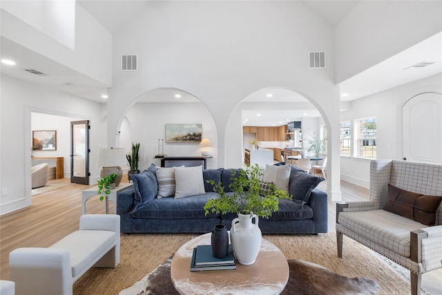 living room featuring light wood-type flooring and high vaulted ceiling