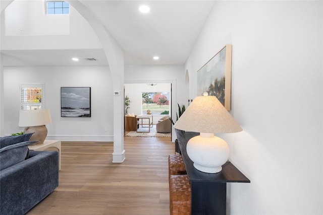 hall featuring a healthy amount of sunlight and hardwood / wood-style flooring