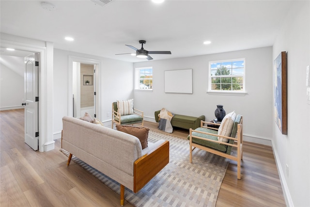 living room featuring ceiling fan, a healthy amount of sunlight, and light wood-type flooring