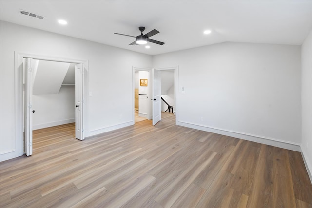 unfurnished bedroom with ceiling fan, vaulted ceiling, a closet, and light hardwood / wood-style flooring