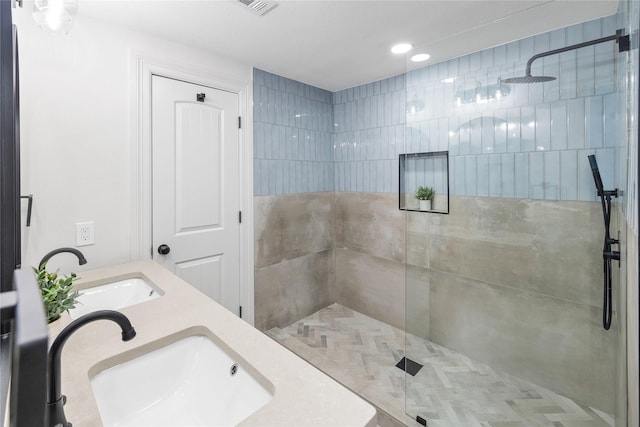 bathroom featuring a tile shower and vanity