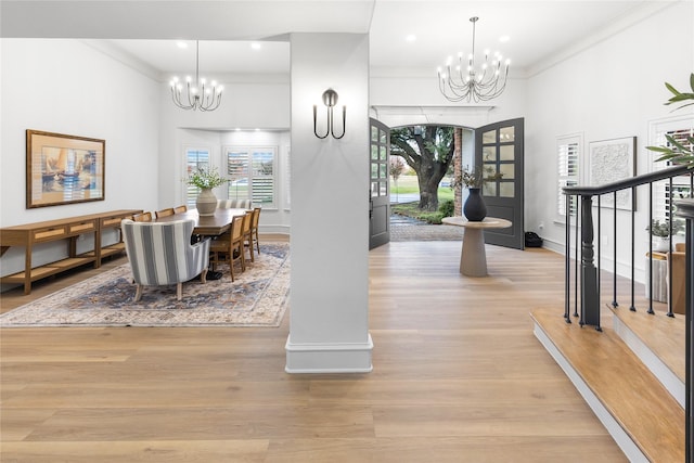 dining area featuring light hardwood / wood-style flooring, an inviting chandelier, and ornamental molding