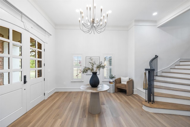 entrance foyer with a chandelier, wood-type flooring, and ornamental molding