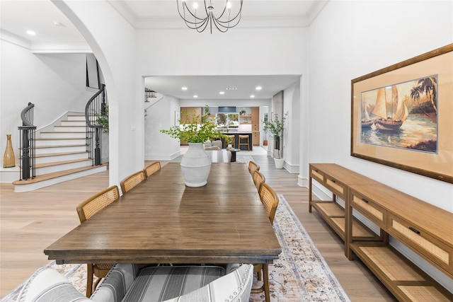 dining room featuring light hardwood / wood-style floors, a notable chandelier, and ornamental molding