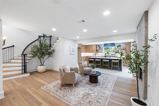 living room featuring light hardwood / wood-style flooring and sink