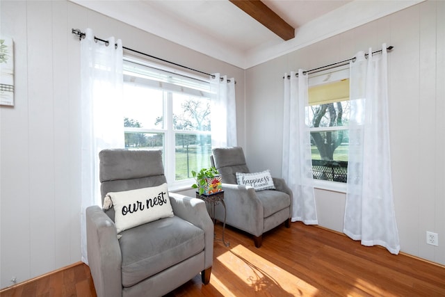 living area featuring beam ceiling and hardwood / wood-style floors