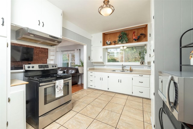 kitchen with white cabinets, sink, light tile patterned flooring, and stainless steel appliances