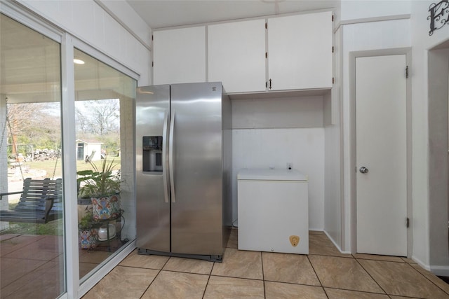 kitchen featuring light tile patterned floors, white cabinetry, and stainless steel fridge