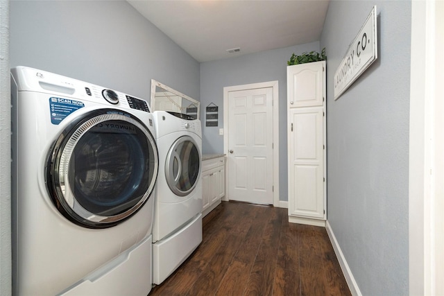 washroom with cabinets, dark hardwood / wood-style flooring, and washing machine and dryer