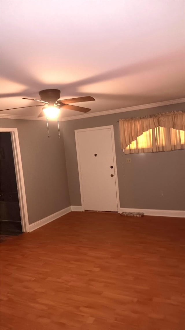 spare room featuring wood-type flooring, ceiling fan, and ornamental molding