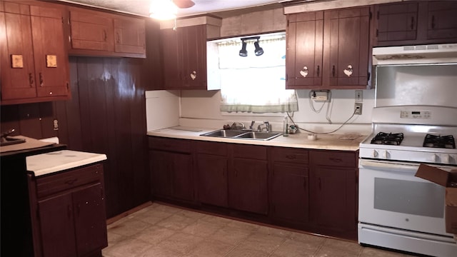 kitchen featuring white range with gas cooktop, sink, and exhaust hood