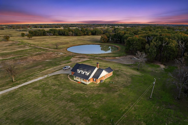 aerial view at dusk featuring a water view